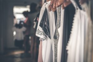 Weiße und dunkle Kleidung auf Kleiderbügeln auf Kleiderstange