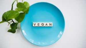Schriftzug vegan auf blauem Teller