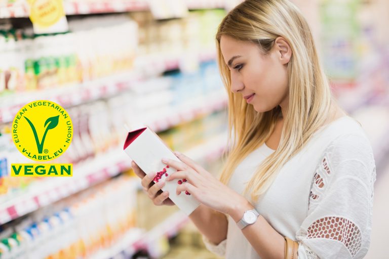Frau im Supermarkt liest Zutatenliste auf einem Produkt
