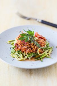 Lupine Bolognese mit Zucchini Spaghetti auf weißem Teller