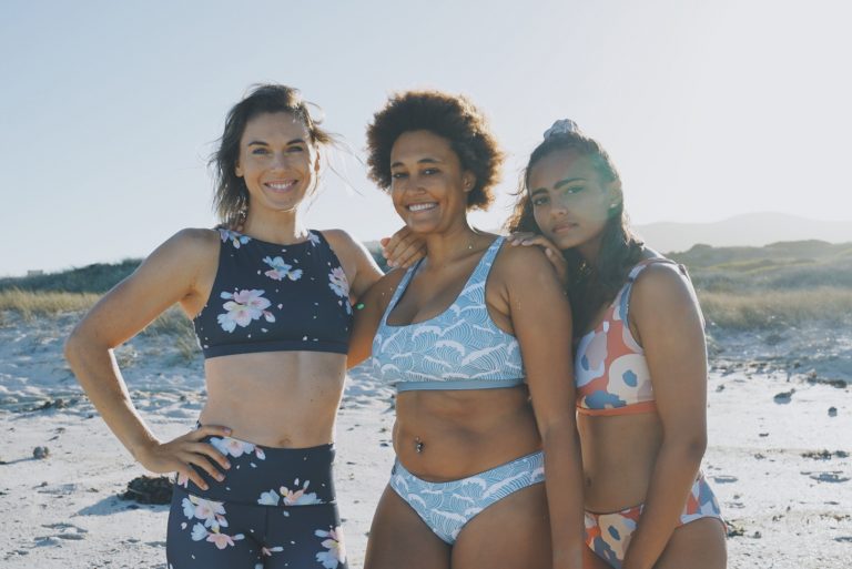 Drei Personen am Strand, die vegane Bdemode von Boochen tragen