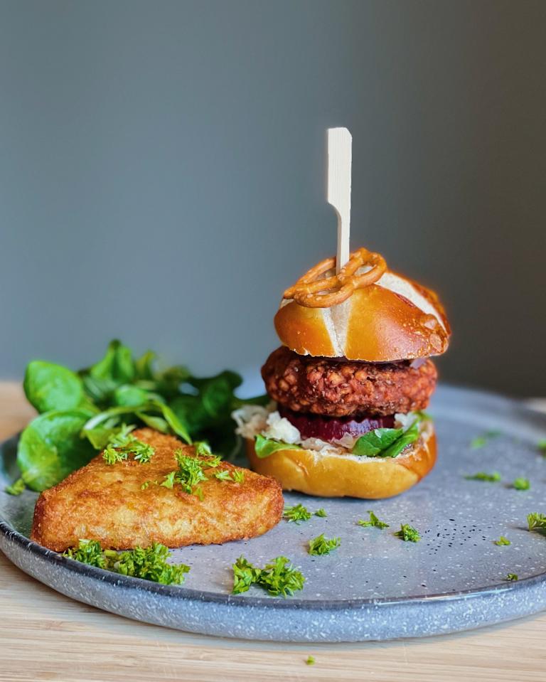 Bayern-Burger vegan: veganer Burger mit Laugenbrötchen, veganem Patty, Sauerkraut, Feldsalat und Rösti