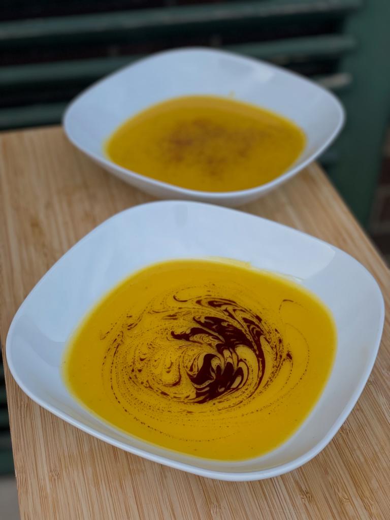 Zwei Teller mit veganer Buternut-Kürbis Suppe
