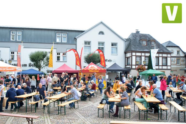 Festival vegan: Der vegane Markt in Ahrweiler: Menschen sitzen an Biertischgarnituren auf einem Marktplatz