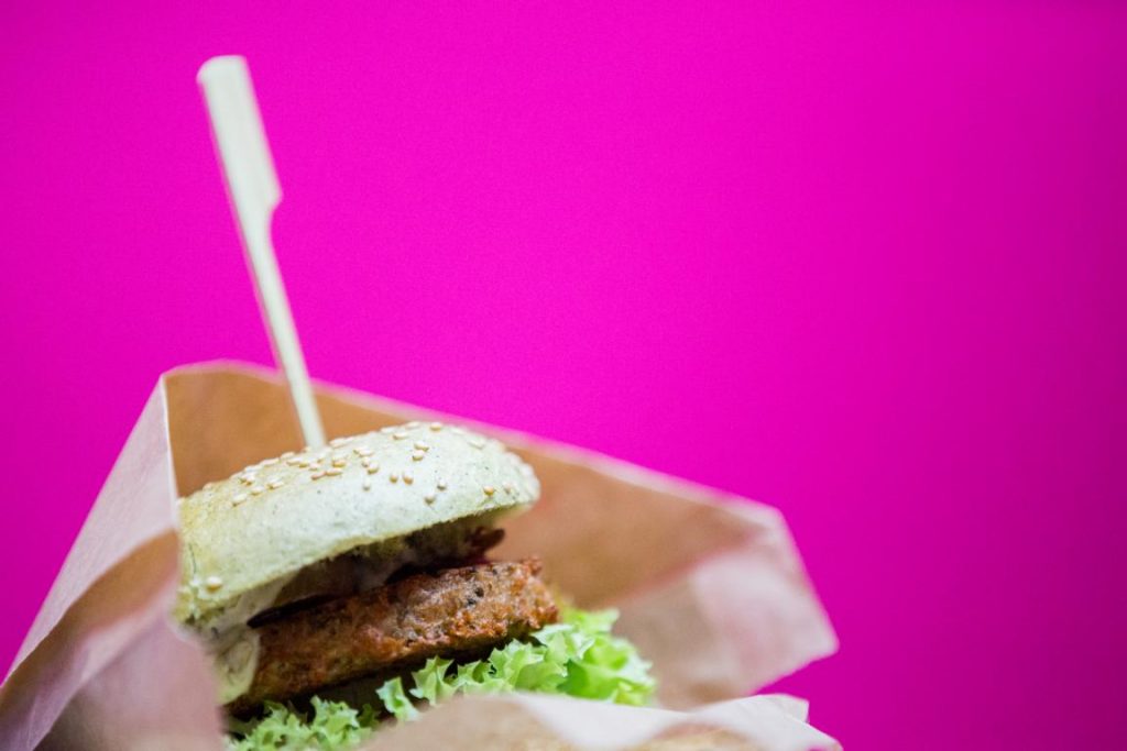 Veganer Burger vor pinkem Hintergrund