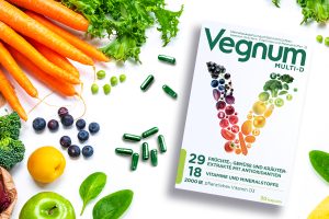 Verpackung von Veganem Nahrungsergänzungsmittel neben Obst und Gemüse